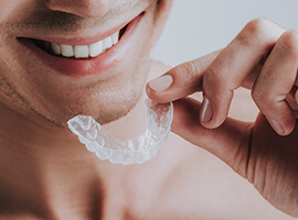 Man using transparent mouthguard to protect his dental implants