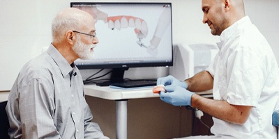 Dentist and patient discussing procedure for implant dentures