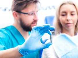 Dentist using model to explain guided dental implant surgery