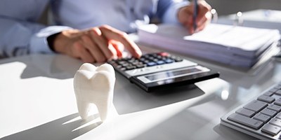 dentist calculating the cost of dental implants in Carmichael